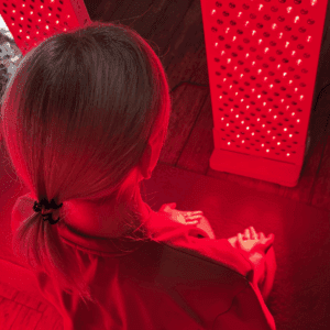 Kobieta podczas naświetlania lampą na podczerwień RedBoost od EyeShield