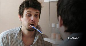 Niewyspany mężczyzna myjący zęby - skutki niedoboru snu EyeShield